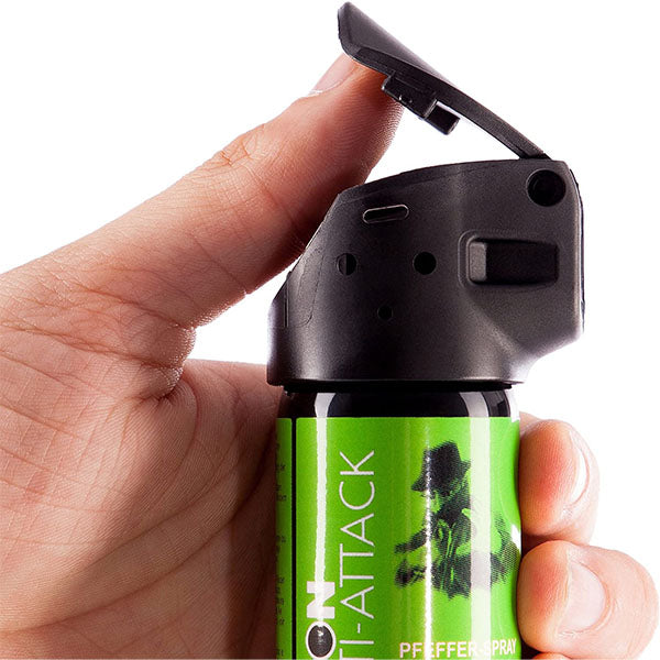 Pava – Hand hält den grünen CANNON ANTI ATTACK 33 ml Daumen liegt am Auslöser bereit zur Anwendung