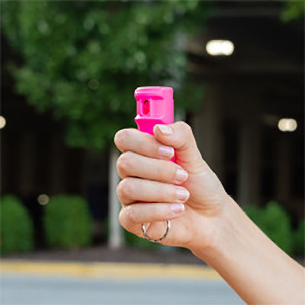 Pfefferspray F15 PEPPER GEL pink 15 ml – eine Hand hält das pinke Pfefferspray mit Fingergriff und Schlüsselring in der Hand