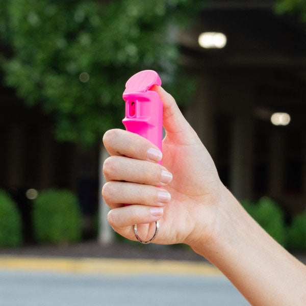 Pfefferspray F15 PEPPER GEL pink 15 ml – eine Hand hält das pinke Pfefferspray, der Daumen liegt am Auslöser, bereit zur Anwendung